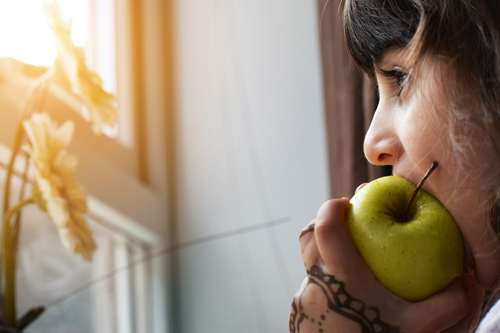 Zioła w kosmetykach: naturalna pielęgnacja skóry i włosów woman biting apple